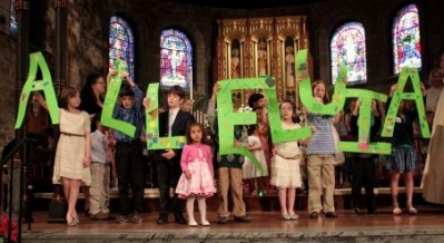 Children hold up letters spelling 